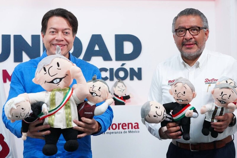 Del lado izquierdo, el Senador Ricardo Monreal y del lado derecho, el Gobernador de Morelos, Cuauhtémoc Blanco. Ambos sonríen y sostienen muñecos de peluche que los representan a ellos mismos.