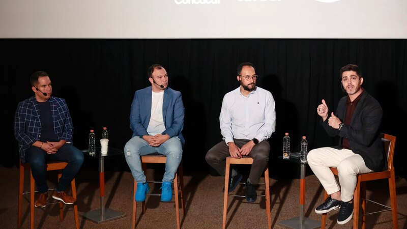 Tres hombres en un panel de discusión