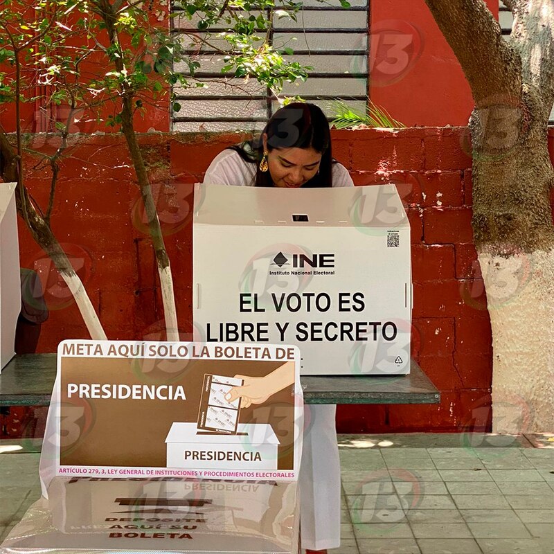 Title: Mujer ejerciendo su derecho al voto en una casilla electoral