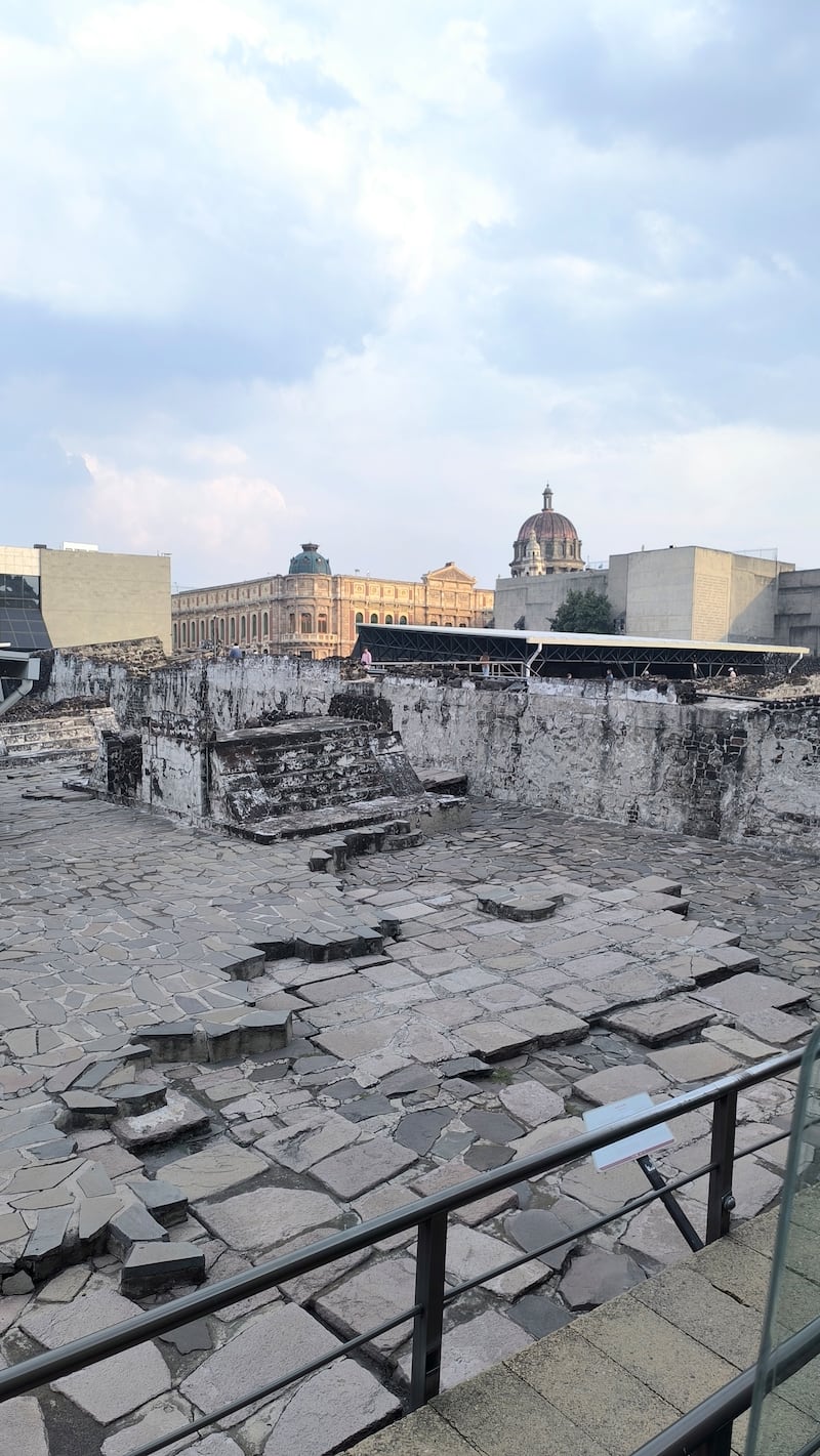 Fotografía de los vestigios del Templo Mayor (Tenochtitlan) con edificios de fondo en el Centro Histórico de CDMX.