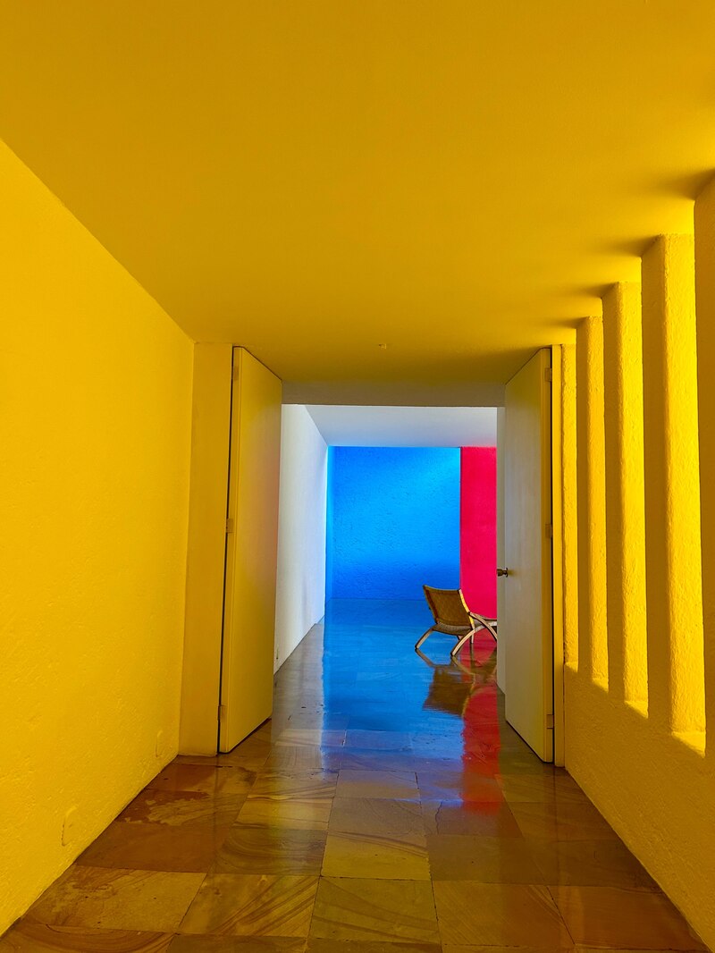 Piscina interior de la Casa Gilardi, rodeada por muros magenta y amarillos con luz cenital