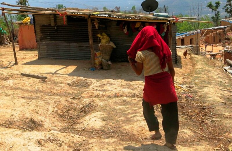 Mujer camina por un terreno baldío en Nepal