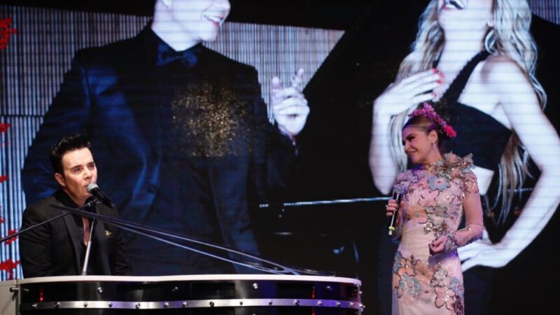 Shakira y Alejandro Sanz cantando juntos en un concierto.