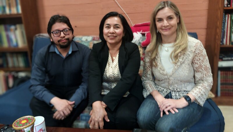 Tres personas sonríen para una foto.