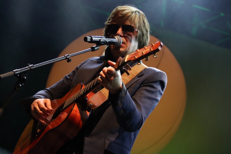 Un cantante tocando la guitarra en un concierto