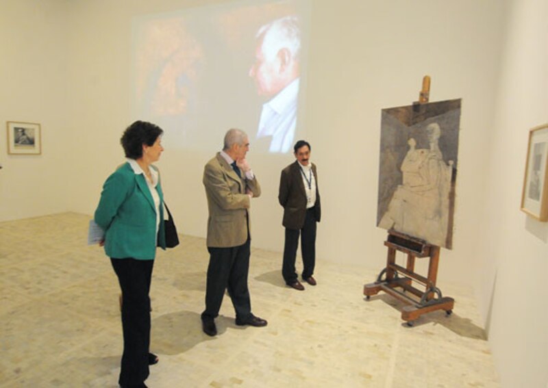 Visitantes observan una pintura en un museo