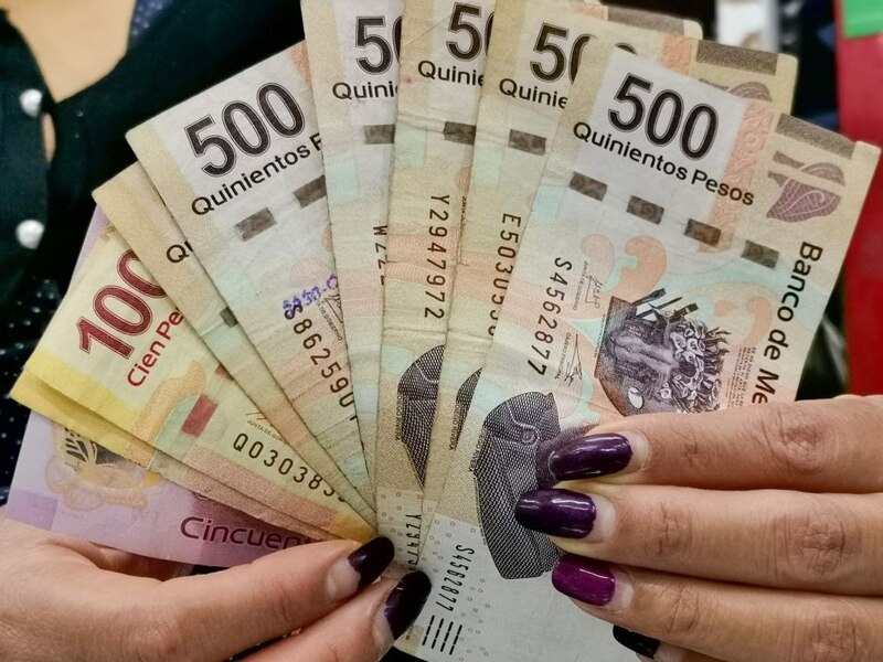 Mujer sosteniendo billetes de 500 pesos mexicanos