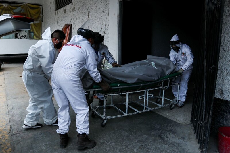 Personal médico traslada el cuerpo de una persona fallecida por COVID-19