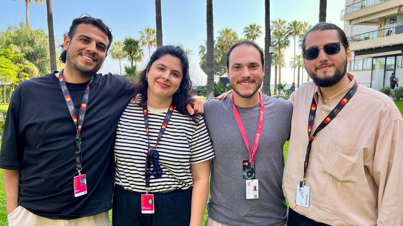 Un grupo de cuatro jóvenes sonríe para una foto en un festival de cine