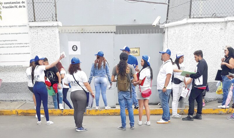 Jóvenes hacen fila para obtener su constancia de liberación del servicio militar.