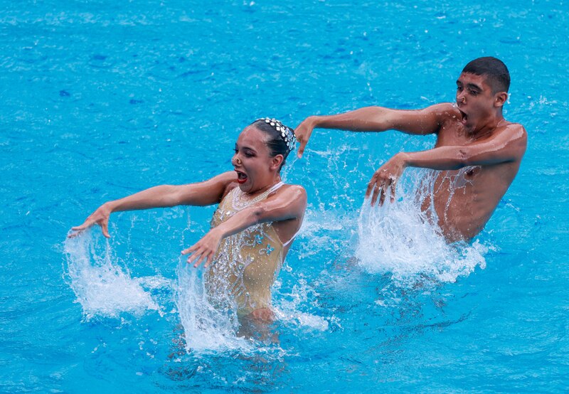 Nadadores sincronizados realizan una rutina en el agua