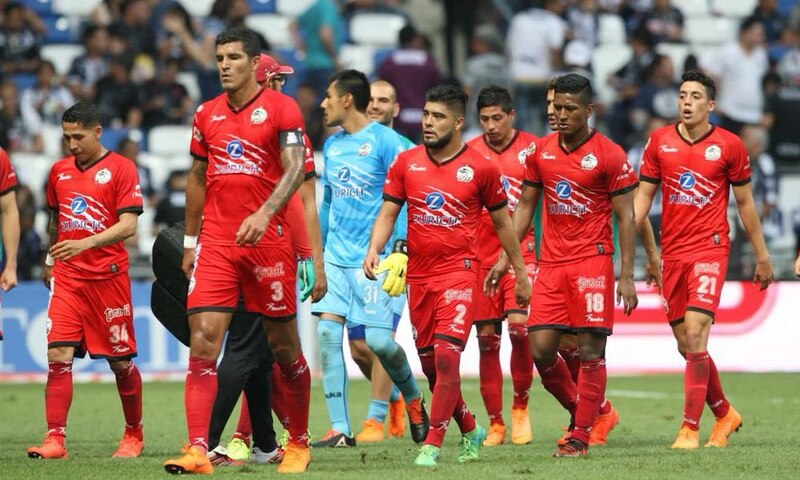 Jugadores de fútbol del Club León cabizbajos tras perder un partido.