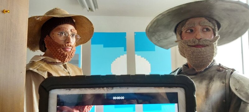 Dos hombres con barbas postizas y sombreros miran fijamente a la cámara