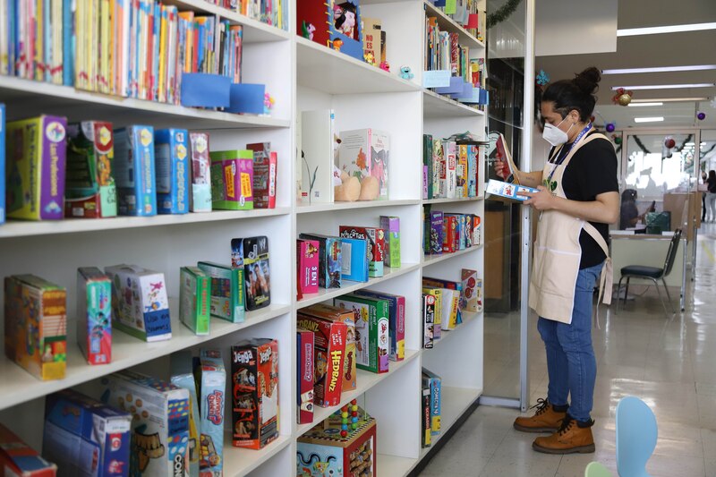 Biblioteca con estanterías de libros y juegos de mesa