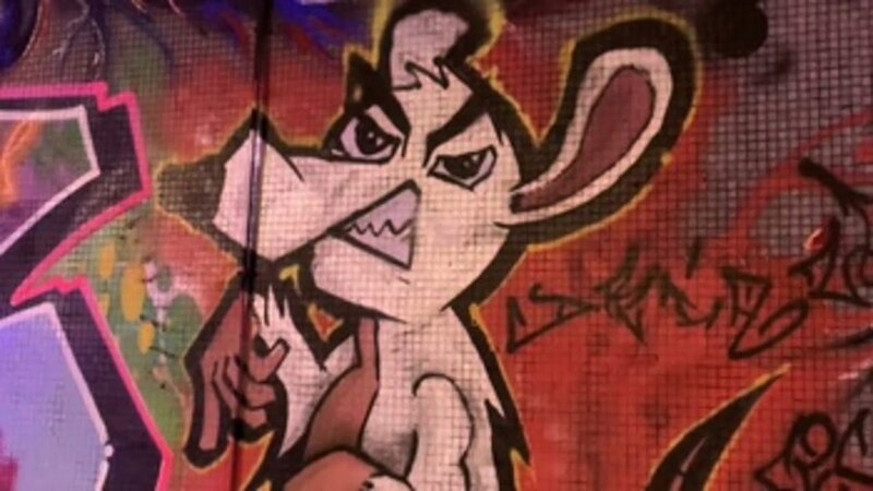 Rata de caricatura con actitud desafiante pintada en una pared