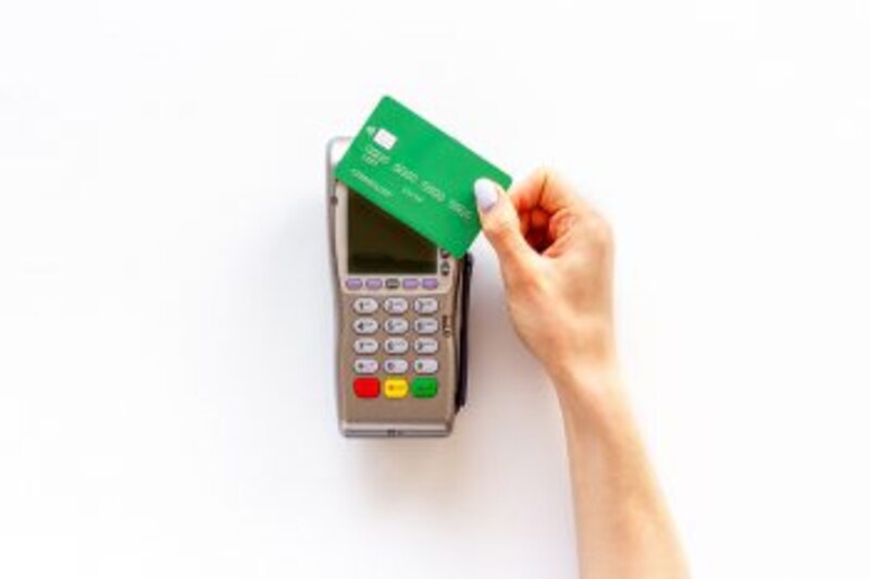 Mujer usando tarjeta de crédito en datáfono