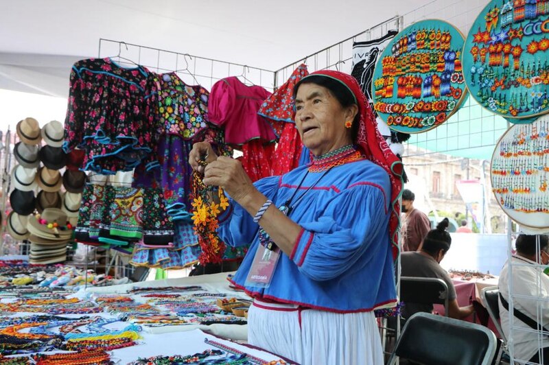 Mujer indígena mexicana vendiendo artesanías en un mercado