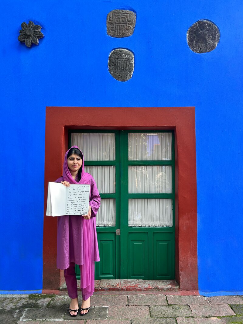 Malala firma el libro de visitantes de La Casa Azul, dejando un mensaje sobre la inspiración de Frida.