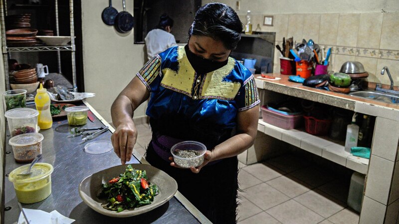 Mujer preparando una ensalada en un restaurante