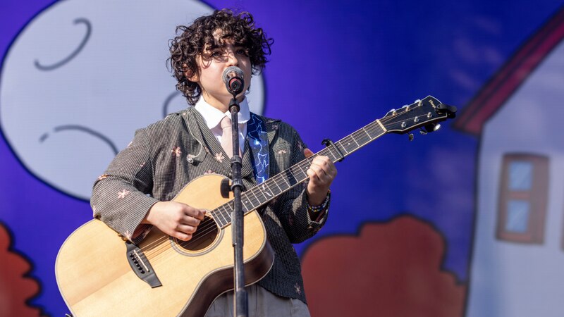 Cantante tocando la guitarra en un concierto