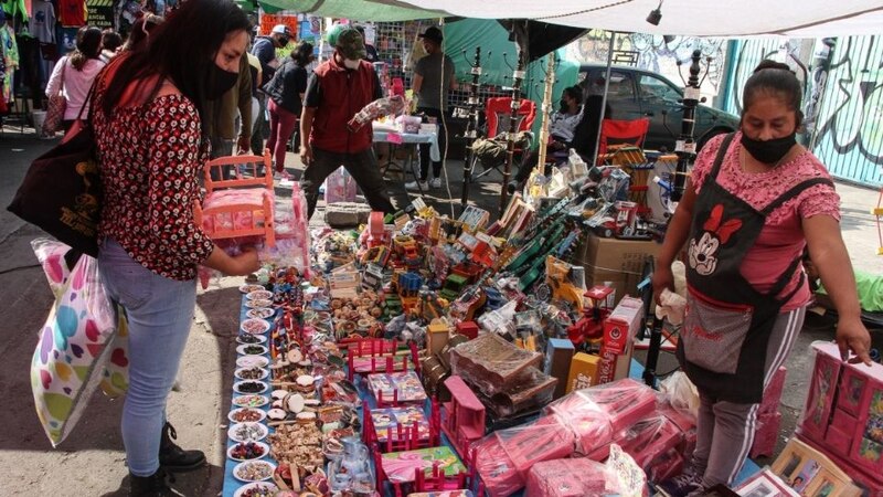 Mujer comprando juguetes en un mercado mexicano