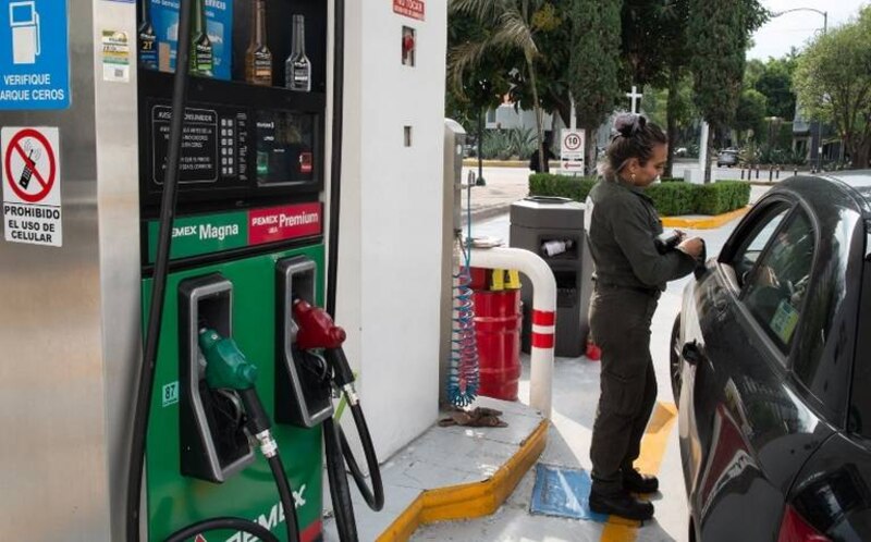 Mujer cargando gasolina en una gasolinera