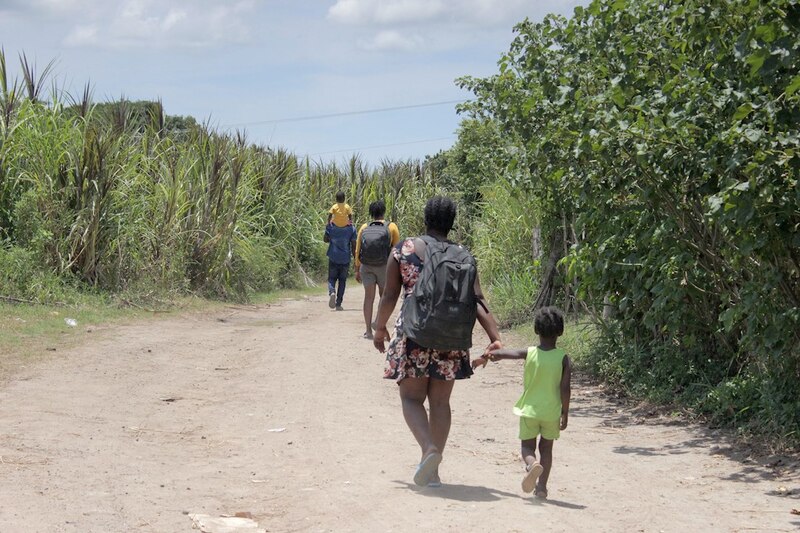 Familia migrante caminando por un sendero rural