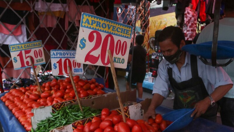 Title: Un vendedor de tomates en un mercado