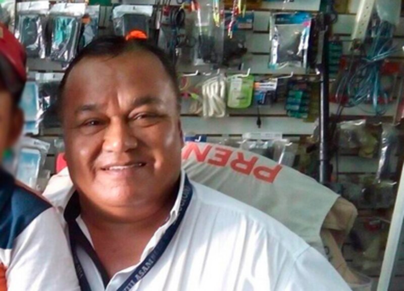 El dueño de una tienda de electrónica sonríe a la cámara.