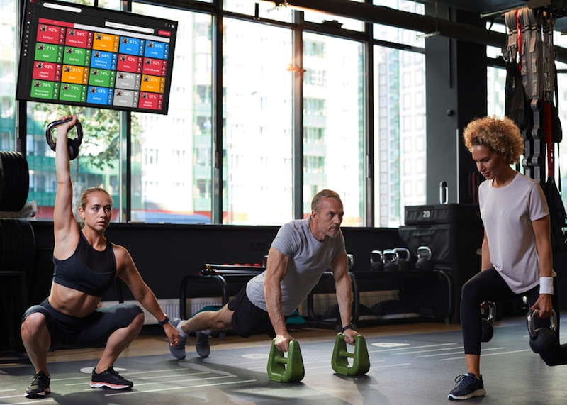 Tres personas haciendo ejercicio en un gimnasio