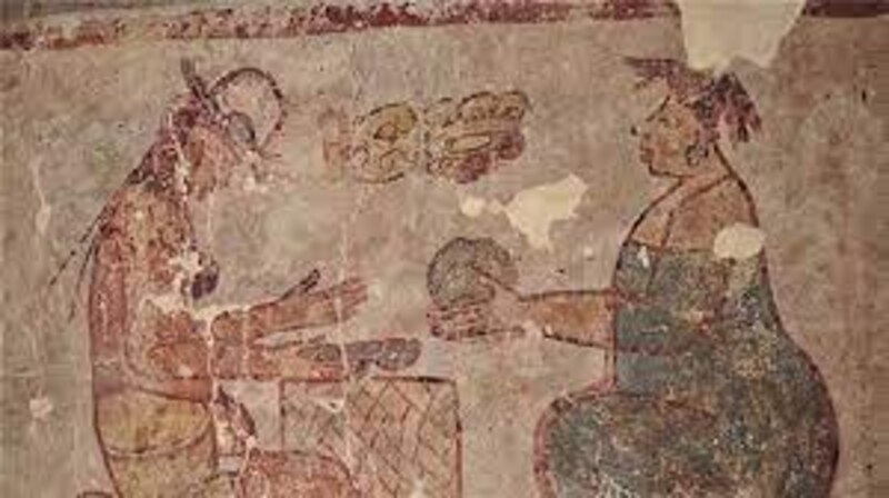 Mujer maya ofrece comida a un hombre sentado