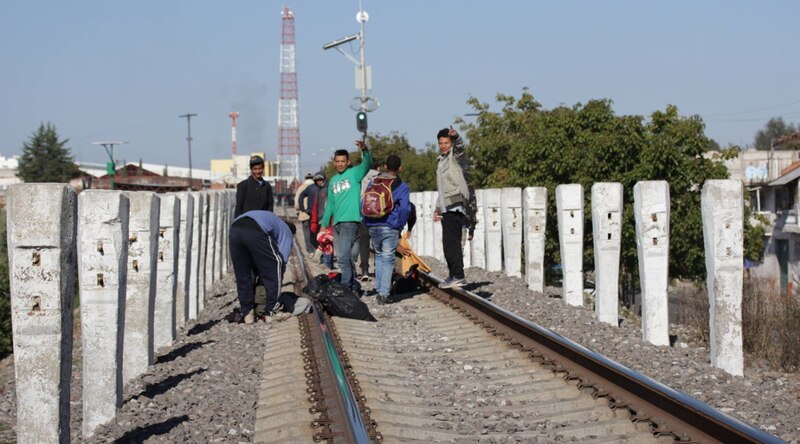 Migrantes caminan sobre las vías del tren en busca del sueño americano