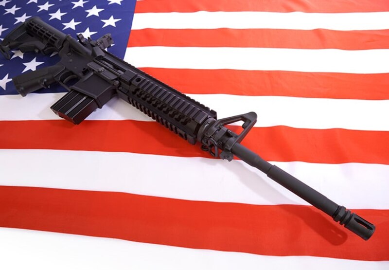 Fusil AR-15 sobre la bandera de Estados Unidos