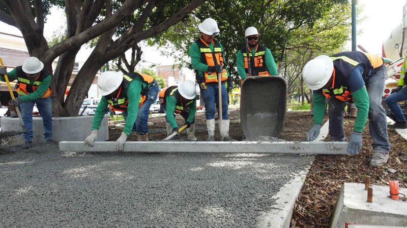 Trabajadores de la construcción vierten concreto en un parque