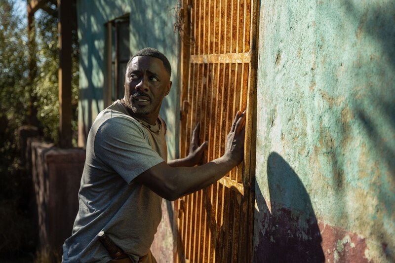 Un hombre negro intenta abrir una puerta oxidada.