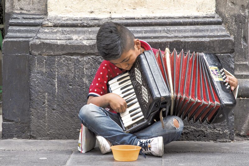 Niño tocando el acordeón en la calle