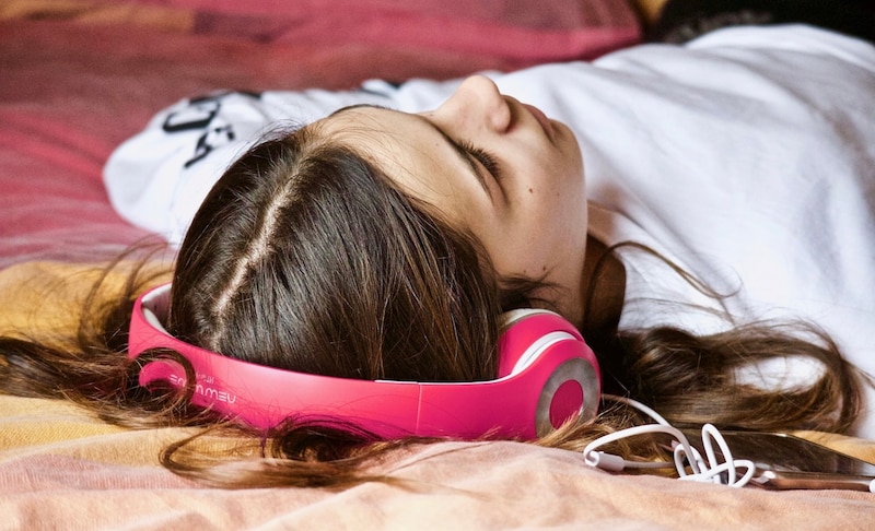 Una joven se relaja escuchando música con auriculares.