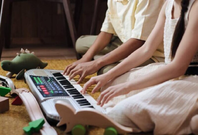 Niño y niña tocando un teclado juntos