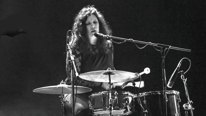 Baterista mujer tocando la batería en un concierto
