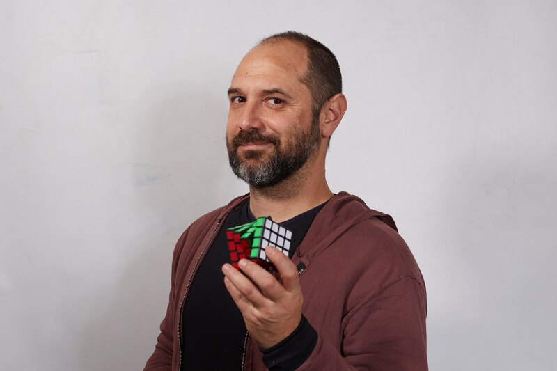 Un hombre sostiene un cubo de Rubik en sus manos