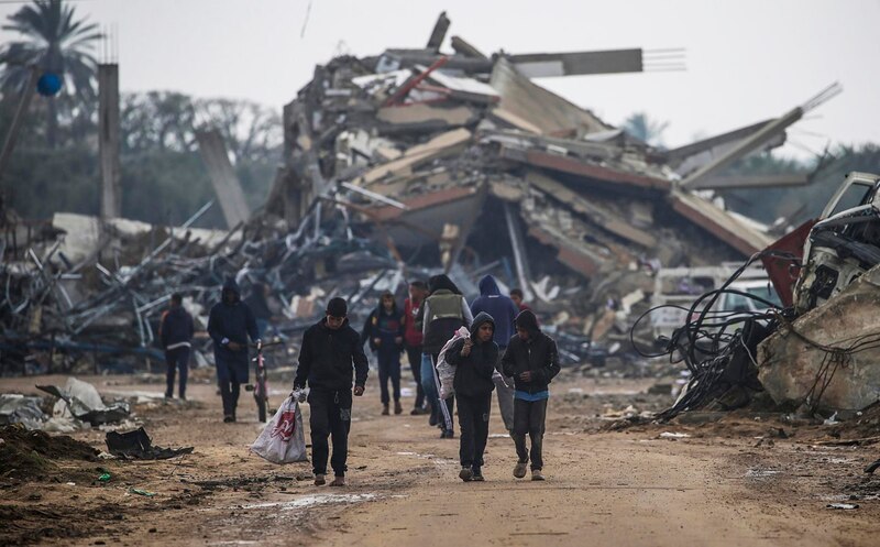 Niños caminando entre los escombros de la guerra