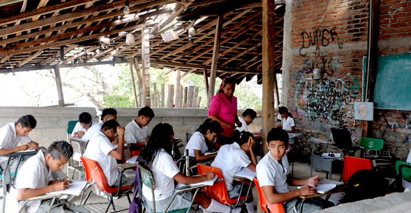 Profesora de primaria da clases en un aula destartalada