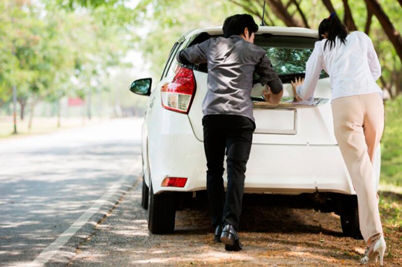 Pareja empujando un coche