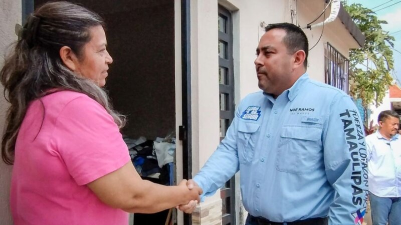 Candidato saluda a mujer en la puerta de su casa