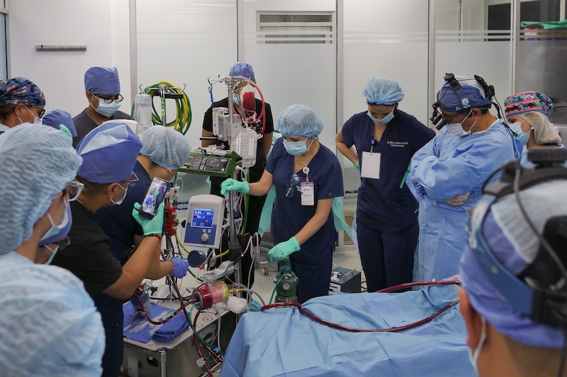 Equipo médico en quirófano durante una cirugía a corazón abierto