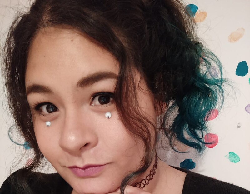 Mujer joven con piercing en los ojos