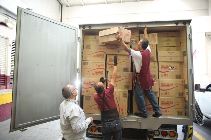 Obreros cargando cajas de productos en un camión