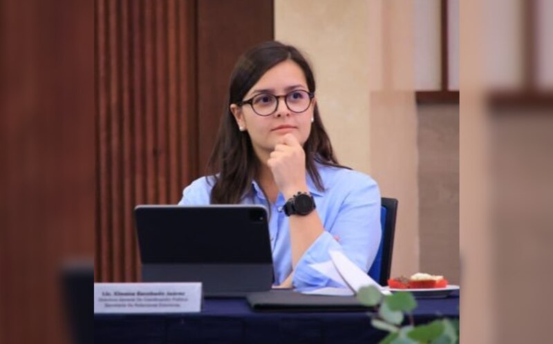 La estudiante universitaria Diana sentada en una mesa con un ordenador portátil.