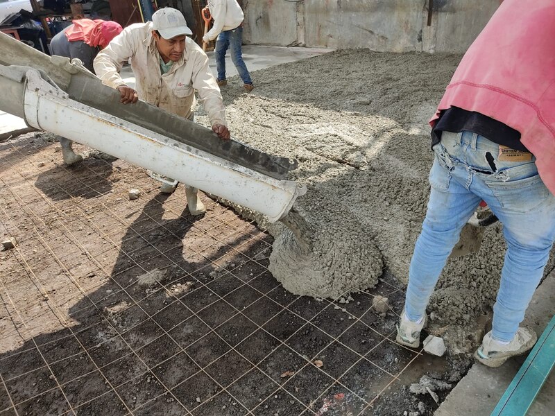 Obreros vierten concreto en una losa de cimentación