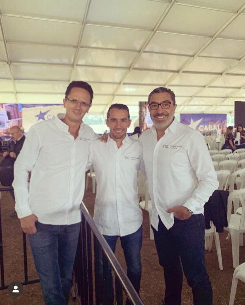Tres hombres sonríen para una foto